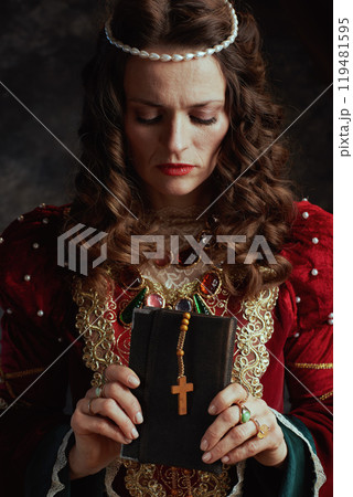 medieval queen in red dress with book and rosary medieval queen in red dress with book and rosary 119481595