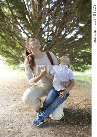A woman and a child are sitting in a park 119481825