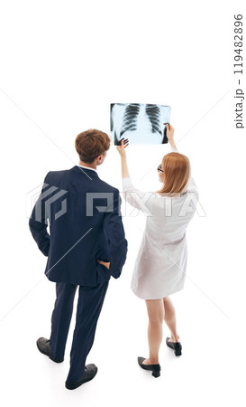 Female doctor, healthcare professional and businessman analyzing X-ray results. Professional consultation in medicine. 119482896