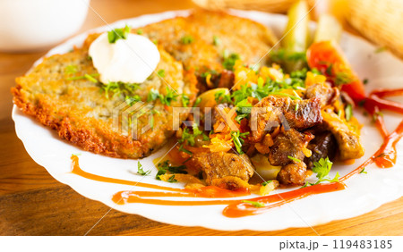 Potato pancakes with grilled beef dish on a white plate Potato pancakes with grilled beef dish on a white plate 119483185