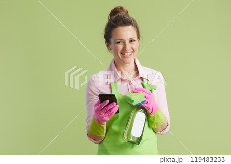 happy woman in green apron and rubber gloves on green 119483233