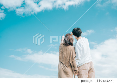 秋の青空を見ながら寄り添う男女の後ろ姿 119483271