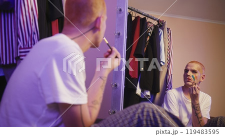 Homosexual man drawing LGBT flag on cheek 119483595