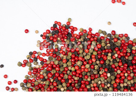 Red, green, white and black peppercorns on a white background top view. Red, green, white and black peppercorns on a white background top view. 119484136
