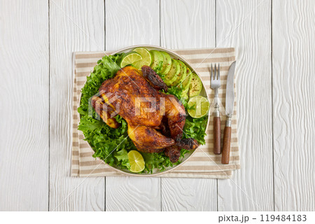 whole roasted chicken with avocado, lime on plate whole roasted chicken with avocado, lime on plate 119484183