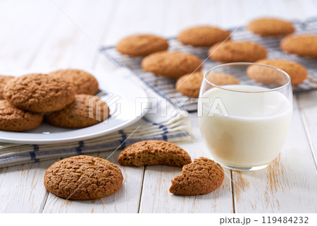 Tasty oatmeal cookies and glass milk on a light kitchen table, selective focus. 119484232