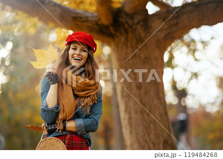 Portrait of smiling stylish woman in jeans shirt and red hat Portrait of smiling stylish woman in jeans shirt and red hat 119484268