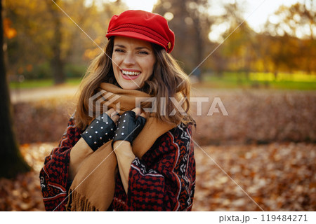 Portrait of happy stylish woman in red hat with scarf 119484271