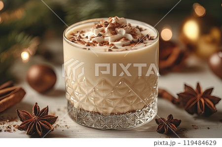 Christmas drink with cinnamon sticks and anise stars, glasse of sweet classic eggnog cocktail on Christmas, New Year decorated background with fir tree and baubles 119484629