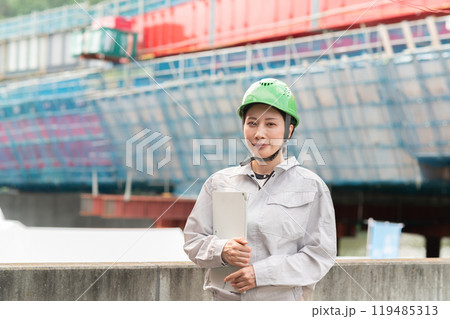 橋の建設現場とヘルメットを被った作業服姿の女性 119485313