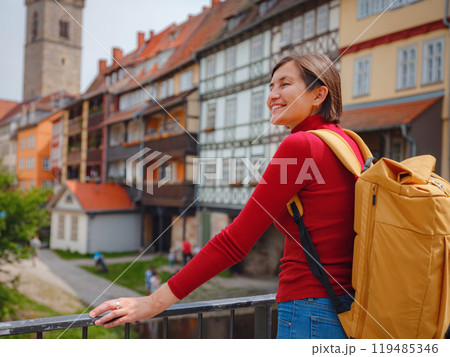 Tourist woman explores beautiful city of Erfurt, wandering through its historic streets, admiring charming architecture, and discovering cultural landmarks, fully immersed in citys rich heritage. Tourist woman explores beautiful city of Erfurt, wandering through its historic streets, admiring charming architecture, and discovering cultural landmarks, fully immersed in citys rich heritage. 119485346