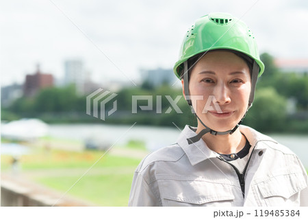 河川調査をするヘルメットをかぶった作業服姿の女性 河川調査をするヘルメットをかぶった作業服姿の女性 119485384
