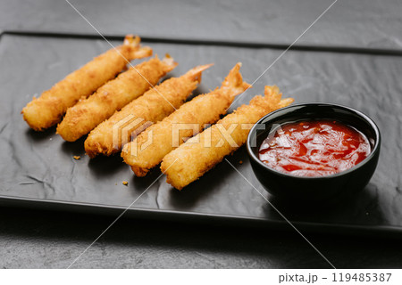 Golden fried shrimp sticks with crispy breading and dipping sauce. Perfect for appetizers or snacks 119485387