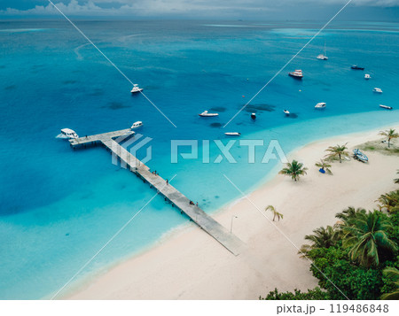 Above view of beach with pier and boats on island. Travel vacation destination, Fulidhoo island. Above view of beach with pier and boats on island. Travel vacation destination, Fulidhoo island. 119486848