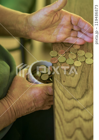 adult senior hands Sorting Small Change into a Container on a Wooden Table. High quality photo 119486873