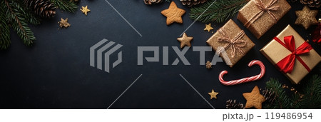 Festive holiday decorations featuring gifts and treats arranged on a dark surface with greenery 119486954