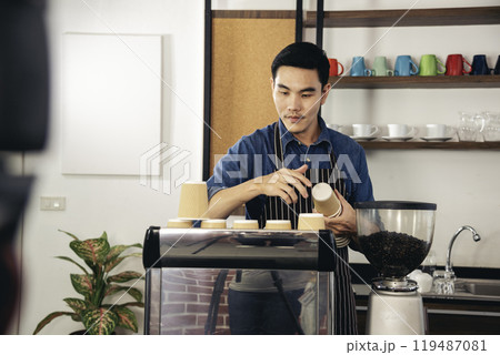 Coffee barista man make espresso shot from coffee maker hot cup. Cappuccino with milk in italian coffee shop cafe. Close up hands of barista use machine make brown latte art for customer cafeteria Coffee barista man make espresso shot from coffee maker hot cup. Cappuccino with milk in italian coffee shop cafe. Close up hands of barista use machine make brown latte art for customer cafeteria 119487081