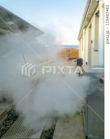 Steaming central heating boiler outside house in Ireland 119487465