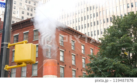 Steam vapor vented, New York City street steam system, orange vapour tube stack. Hot smoke from pipe Steam vapor vented, New York City street steam system, orange vapour tube stack. Hot smoke from pipe 119487876