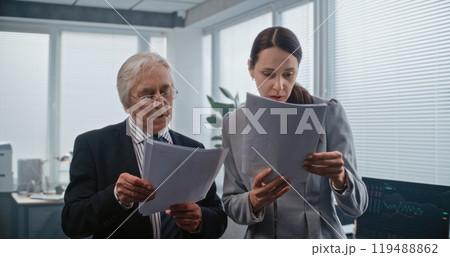 Female employee and team leader have discussion, analyze papers 119488862