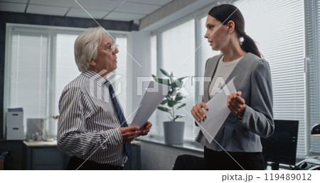 Senior team leader and female employee have discussion in modern office Senior team leader and female employee have discussion in modern office 119489012