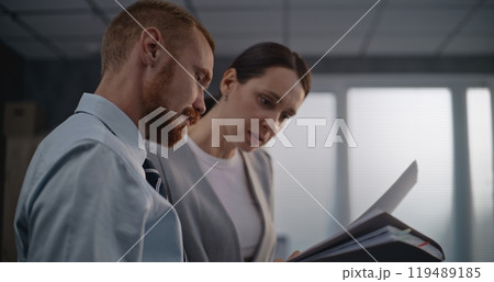 Portrait of two financial specialists watching documents, discussing project ideas 119489185