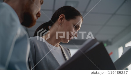 Portrait of two financial specialists studying documents, brainstorming project ideas 119489227