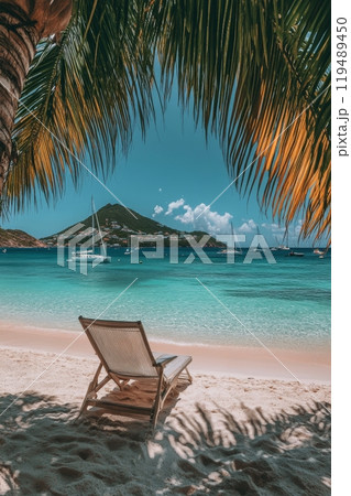 Relaxing beachside view with a wooden lounge chair and distant sailboats under a blue sky 119489450
