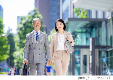 オフィス街を歩くシニアビジネスマン 男女 オフィス街を歩くシニアビジネスマン 男女 119489851