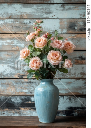 Beautiful pastel roses in a ceramic vase against a rustic wooden backdrop 119490345