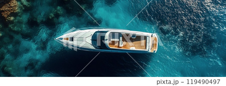 A luxury yacht cruises through clear blue waters on a sunny day in a tropical location 119490497