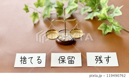 天秤と3枚のカードに捨てる保留残すの文字_茶色背景 119490762