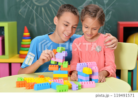 Little brother and sister assemble a construction set at home 119491571