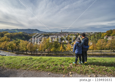 Bern (Berne) Switzerland love couple tourists looking at old town and Aare River in autumn season 119491631