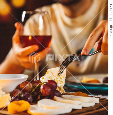 Man having cheese and wine tasting with friends at home 119492474