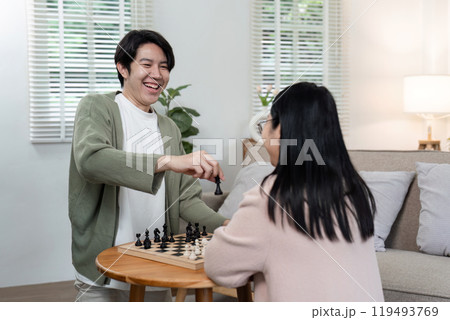 Mother and Son Enjoying Quality Time Playing Chess Together in a Cozy Modern Living Room 119493769