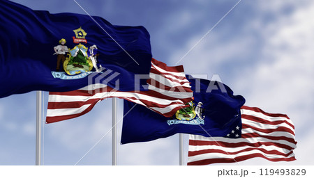Maine state flags and the American flag waving in the wind on a clear day Maine state flags and the American flag waving in the wind on a clear day 119493829