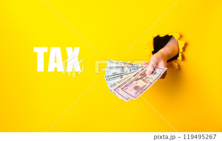 Hand holding cash with tax text on yellow background Hand holding cash with tax text on yellow background 119495267