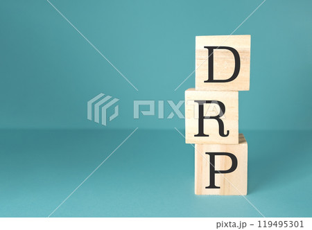 Wooden blocks with the letters DRP on a blue background 119495301