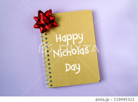 A notebook with a red bow on it with the words Happy Nicholas Day written on it 119495322