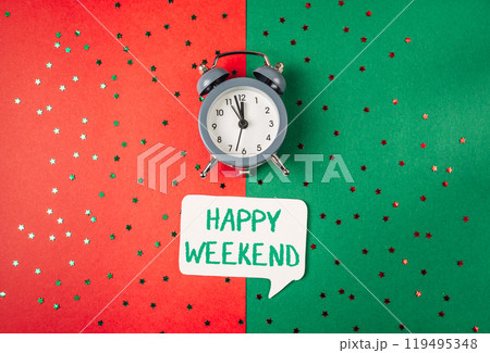 A clock is on a green background with a white sign that says Happy Weekend A clock is on a green background with a white sign that says Happy Weekend 119495348