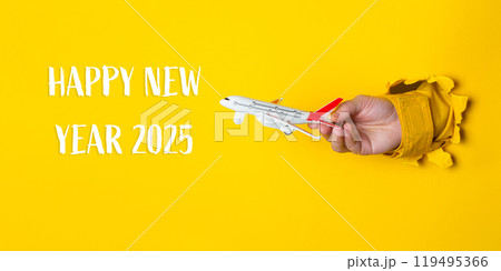 Hand holding a toy airplane in front of a yellow background Hand holding a toy airplane in front of a yellow background 119495366