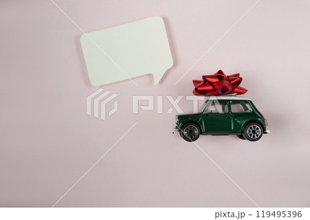 Green toy car with a red bow on top of it 119495396
