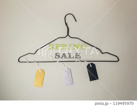 A spring sale sign is hanging on a clothes hanger 119495970