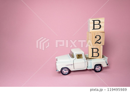 A white truck is carrying a stack of wooden blocks 119495989