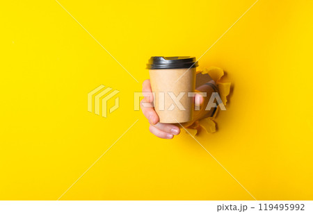 Person is holding a coffee cup with a lid in their hand Person is holding a coffee cup with a lid in their hand 119495992