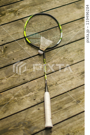 A shuttlecock with a badminton racket on the wooden floor. High quality photo A shuttlecock with a badminton racket on the wooden floor. High quality photo 119496284