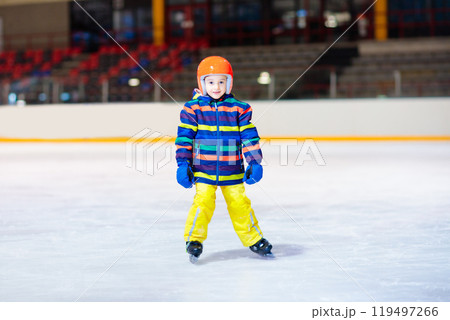 Child skating on indoor ice rink. Kids skate. Child skating on indoor ice rink. Kids skate. 119497266