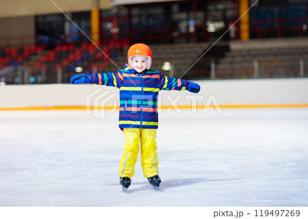 Child skating on indoor ice rink. Kids skate. Child skating on indoor ice rink. Kids skate. 119497269