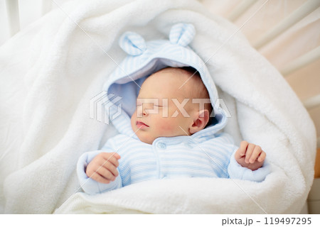 Newborn baby boy in hospital cot 119497295